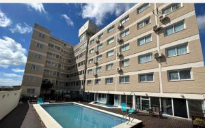 a hotel with a swimming pool in front of a building at hotel Villa Gesell Spa in Villa Gesell