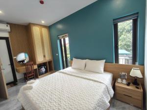 a bedroom with a large bed with a blue wall at Tam Coc Sunflower Hotel in Ninh Binh
