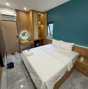 a bedroom with a large bed and a blue wall at Tam Coc Sunflower Hotel in Ninh Binh