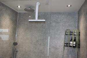 a shower with a glass door with bottles of wine at Lush Rooms Bedminster in Bristol