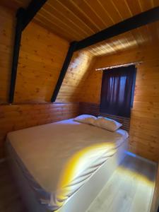 a bed in a wooden room with a window at Mira Bungalov in Trabzon