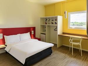 a bedroom with a bed and a desk and a window at ibis Styles Birigui in Birigui +60 photos