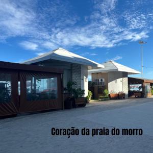 a building with a parking lot in front of it at PRAIA DO MORRO NA QUADRA DO MAR com 2 Quartos sendo 1 Suíte mais Kit Praia e ao lado PRAIA CENTER in Guarapari