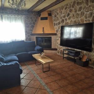 a living room with a blue couch and a tv at Finca Don Sancho by Mayne in Lillo