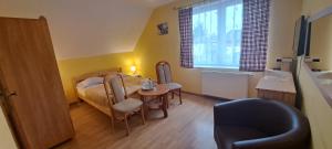 a small room with a bed and a table and chair at Willa Pod Jedlicą in Ciechocinek +27 photos