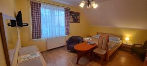 a bedroom with a bed and a table and a chair at Willa Pod Jedlicą in Ciechocinek