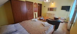 a bedroom with a bed and a table with towels on it at Willa Pod Jedlicą in Ciechocinek