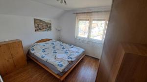 a small bedroom with a bed and a window at Podlugovi House Villa in Podlugovi