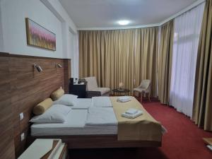 a hotel room with a large bed and chairs at Soba Kašmir in Bugojno +8 photos