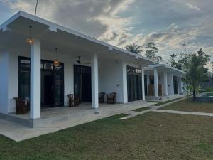 a white building with tables and chairs in a yard at Era 25 in Ahangama