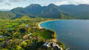an aerial view of a beach and water with mountains at NEW Sunset Hideaway with Beach Access Pools & AC in Princeville