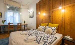 a bedroom with a large bed with a wooden wall at Mignon Szeged Apartman in Szeged