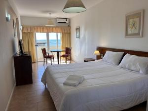 a bedroom with a bed and a table with chairs at hotel Villa Gesell Spa in Villa Gesell +20 photos