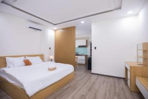 a bedroom with a large white bed and a desk at Board & Beyond House in Danang