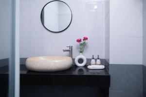 a bathroom with a round sink and a mirror at Board & Beyond House in Danang +10 photos