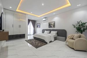 a bedroom with a bed and a couch and a tv at Mex 1 bedrooms Lekki phase1 in Lagos
