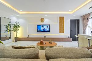 a living room with a couch and a tv on a wall at Mex 1 bedrooms Lekki phase1 in Lagos +8 photos