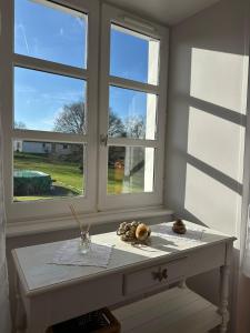 a white table in a room with two windows at Le Nid Douillet in Chirac