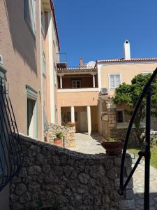 a stairway leading to a building with a stone wall at PALIO LIMANI APARTMENTS in Spetses