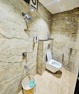 a bathroom with a toilet and a shower at Shankar Bhavan By Vinayak Hotels in Brahmapur