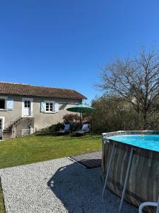 a swimming pool in a yard with a house at Le Nid Douillet in Chirac