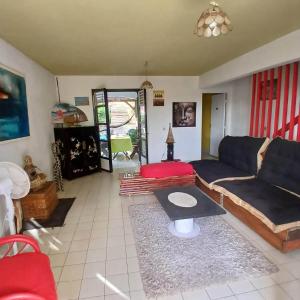 a living room with a couch and a table at Chico's loc in Sainte-Luce