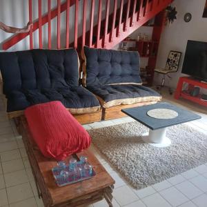 a living room with a couch and a table at Chico's loc in Sainte-Luce