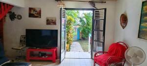 a living room with a tv and a sliding glass door at Chico's loc in Sainte-Luce +26 photos