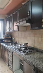 a kitchen with black cabinets and a stove top oven at Appartement 2 chambres bon emplacement Casablanca in Casablanca