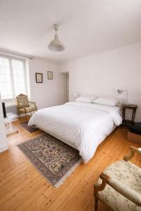 a bedroom with a large white bed and a rug at Maison Suzanne, Downtown, 6 Guests in Cancale