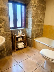 a bathroom with a tub and a toilet and a sink at LS Alojamiento Turístico in Arcade +19 photos
