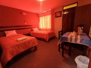 a hotel room with two beds and a table at Colca Terra in Chivay