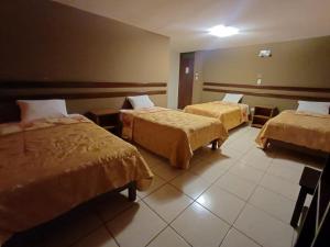 a hotel room with three beds in a room at Colca Terra in Chivay