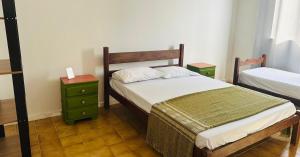 a bedroom with two beds and two night stands at PRAIA DO MORRO NA QUADRA DO MAR com 2 Quartos sendo 1 Suíte mais Kit Praia e ao lado PRAIA CENTER in Guarapari