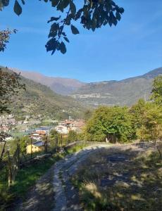 a dirt road with a village in the distance at Casa montagna relax in Cedegolo