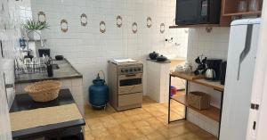 a small kitchen with a stove and a counter at PRAIA DO MORRO NA QUADRA DO MAR com 2 Quartos sendo 1 Suíte mais Kit Praia e ao lado PRAIA CENTER in Guarapari