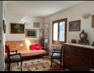 a bedroom with a couch and a table and chairs at Casa montagna relax in Cedegolo