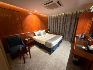 a hotel room with a bed and a chair at كلاديوم in Medina