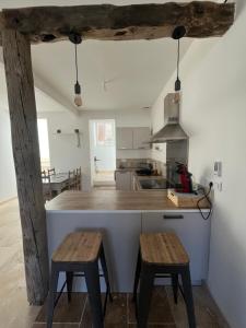 a kitchen with a counter and two wooden stools at la petite colline in Cavaillon