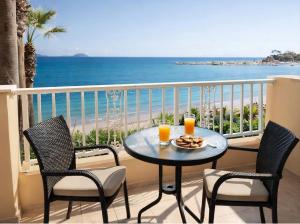 a balcony with a table with two glasses of orange juice at Nel Mare Studios in Laganas