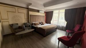 a hotel room with a bed and two chairs at Monroe Hotel in Almaty