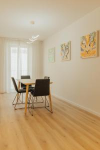 a dining room table with chairs and paintings on the wall at Termas do Gerês Studio in Geres