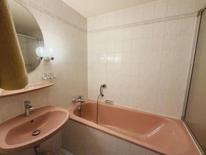 a bathroom with a pink tub and a sink at Hotel Drei Rosen in Borna +12 photos