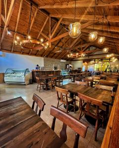 a restaurant with wooden tables and benches and a bar at El Copihue Olmué in Olmué