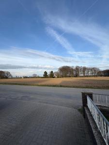 an empty road with a fence next to a field at Landglück in Ibbenbüren