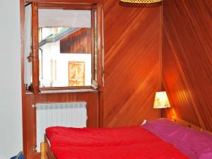 a bedroom with a red bed and a window at Casa Roccaraso in Roccaraso