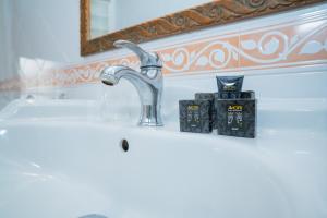 a bathroom sink with a faucet and some books at Joy's Rooms Ortigia in Syracuse +149 photos
