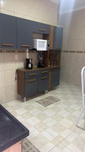 a kitchen with blue cabinets and a microwave at Host Família Catarina in Guarulhos