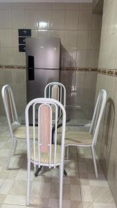 a table with two chairs and a refrigerator at Host Família Catarina in Guarulhos +1 photo