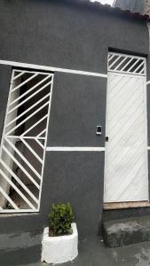 a garage with a white door and two windows at Host Família Catarina in Guarulhos